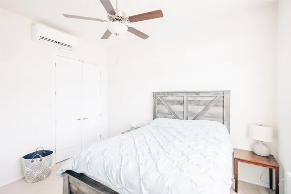 a bedroom with a bed and a ceiling fan