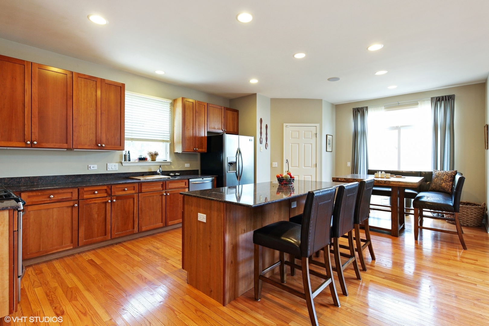 800 De Roo Loop Highwood, IL 60040 - Photo 4 of 22 a kitchen with stainless steel appliances granite countertop wooden floor a table and chairs