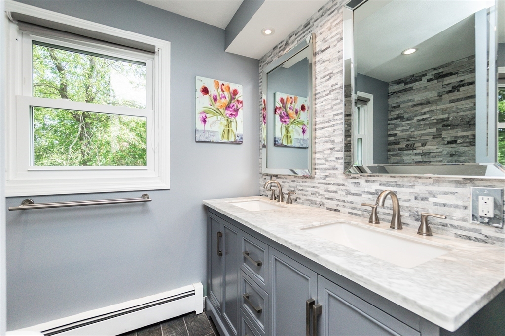 63 Bow Street Saugus, MA 01906 - Photo 16 of 42 a bathroom with a granite countertop sink a large mirror and a window
