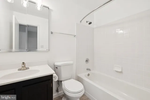 a bathroom with a toilet a sink a mirror and a bathtub