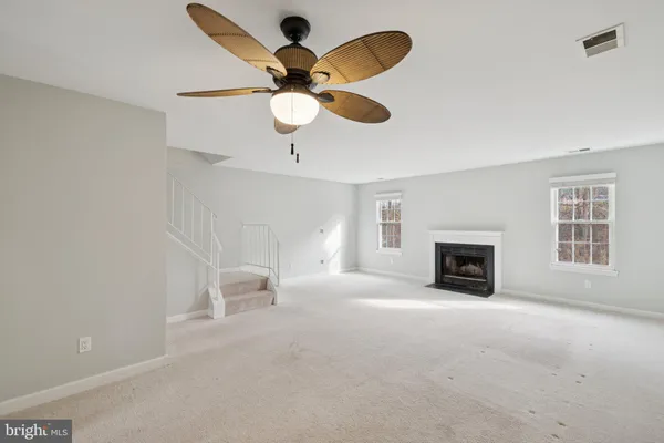 a view of an empty room with a fireplace and a window
