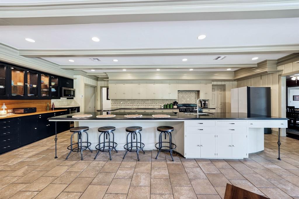 1901 Rose Pointe Athens, TX 75752 - Photo 11 of 37 Kitchen featuring a large central island with seating, dark countertops, built-in cabinetry, recessed lighting, and tile flooring