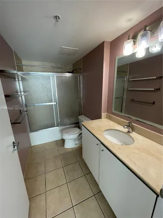 a bathroom with a granite countertop sink a toilet a mirror and shower