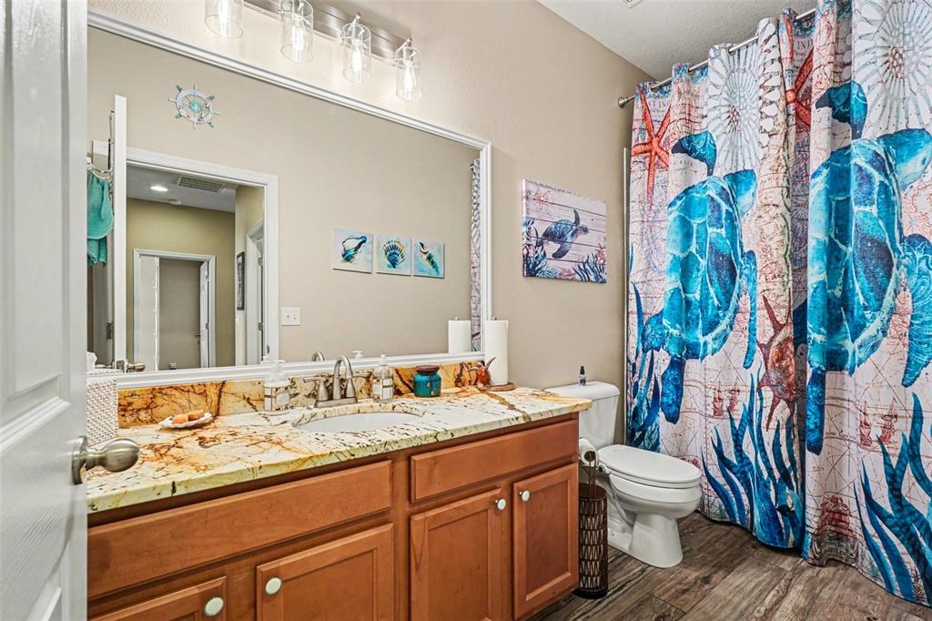 2134 Barracuda Court Holiday, FL 34691 - Photo 26 of 36 a bathroom with a sink a toilet and a shower curtain
