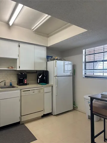 a kitchen with white cabinets and white appliances