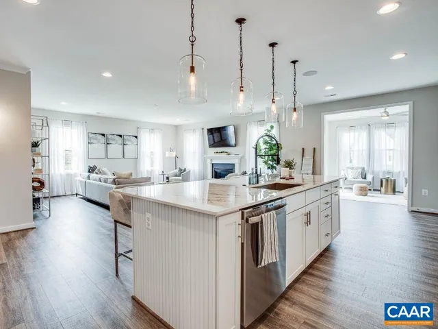 a kitchen with stainless steel appliances kitchen island a large island in the center and wooden floors