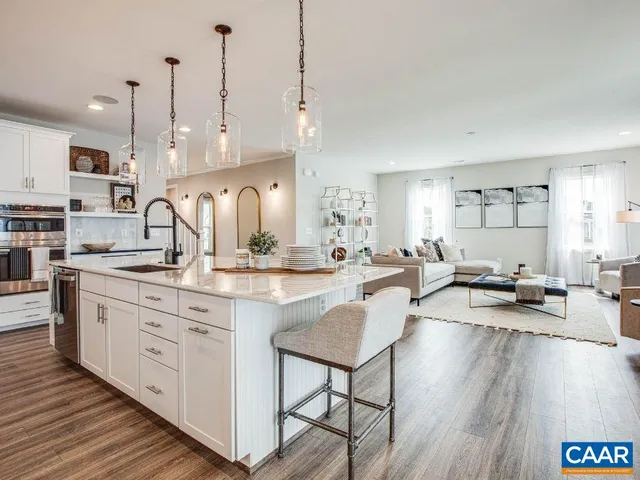 a large kitchen with kitchen island a island a sink a stove and wooden floor