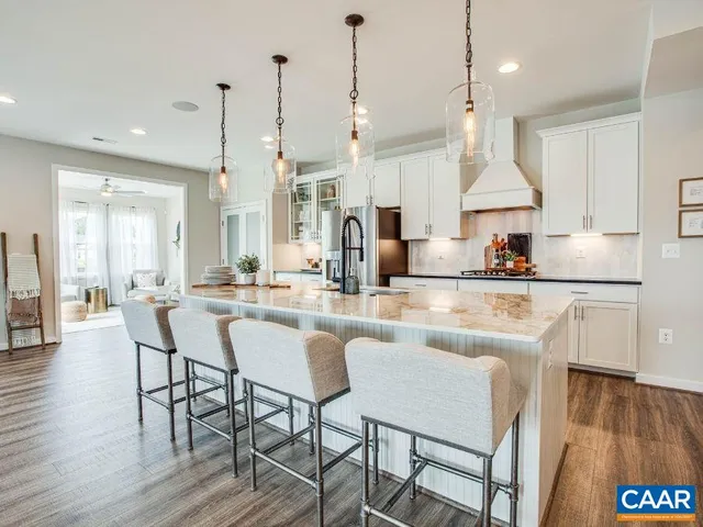 a kitchen with stainless steel appliances granite countertop a kitchen island a stove a table and chairs