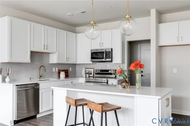 a kitchen with stainless steel appliances granite countertop a sink refrigerator and microwave