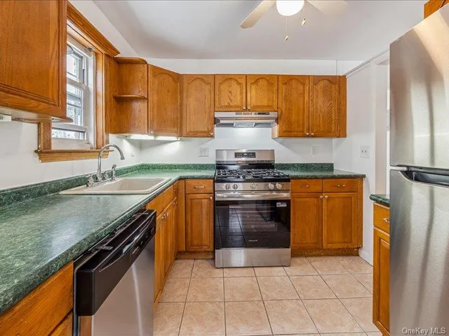 a kitchen with stainless steel appliances granite countertop a stove a sink and a refrigerator