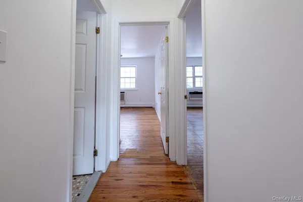 a view of a hallway with wooden floor and closet