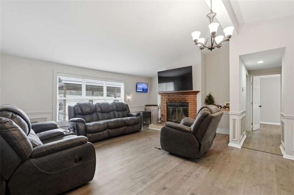 1295 Double Bridges Road Winder, GA 30680 - Photo 23 of 59 a living room with furniture a fireplace and a flat screen tv