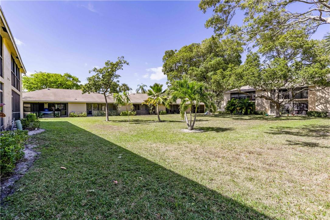 3939 Northeast 5th Avenue, Unit F104 Boca Raton, FL 33431 - Photo 5 of 34 a front view of a house with a yard