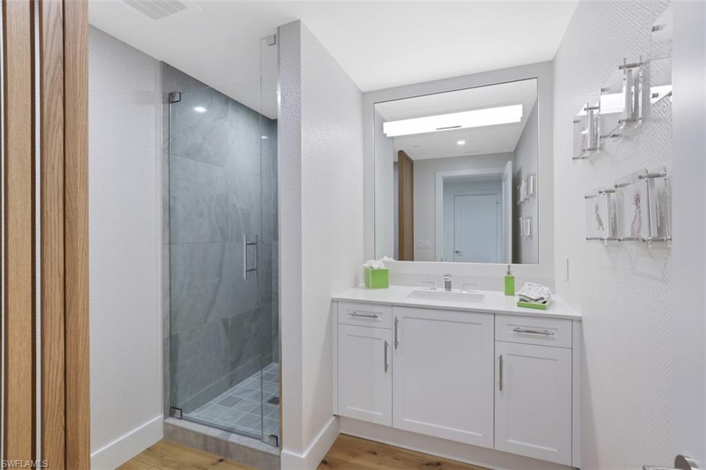 13915 Old Coast Road, Unit 1601 Naples, FL 34110 - Photo 10 of 37 a spacious bathroom with a double vanity sink mirror and shower