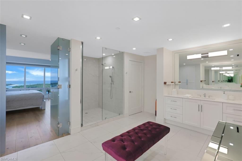 13915 Old Coast Road, Unit 1601 Naples, FL 34110 - Photo 17 of 37 a spacious bathroom with a shower a sink and a mirror