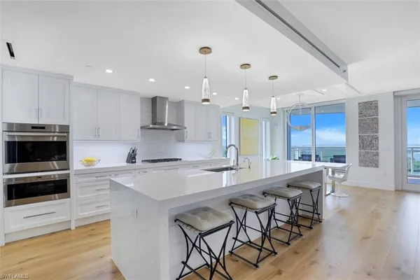 a large kitchen with kitchen island a dining table and chairs