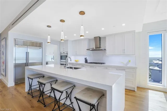 a large kitchen with kitchen island a dining table and chairs