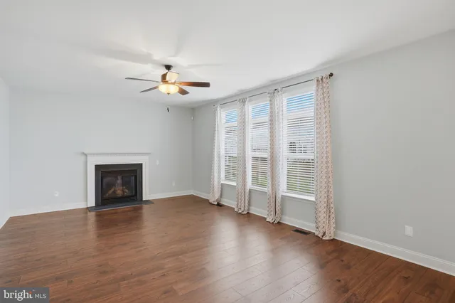 an empty room with wooden floor a ceiling fan and closet