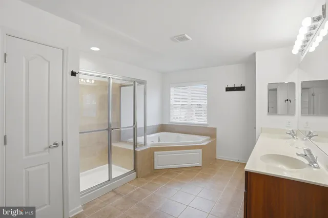 a spacious bathroom with a bathtub sink and mirror