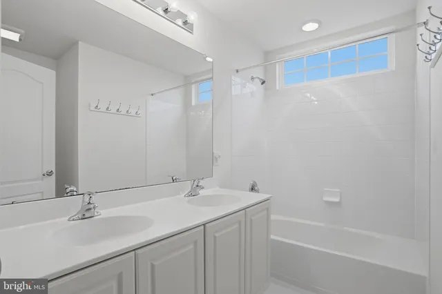 a bathroom with a granite countertop sink and a bathtub