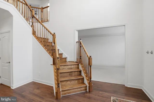 a view of staircase with wooden floor and white walls