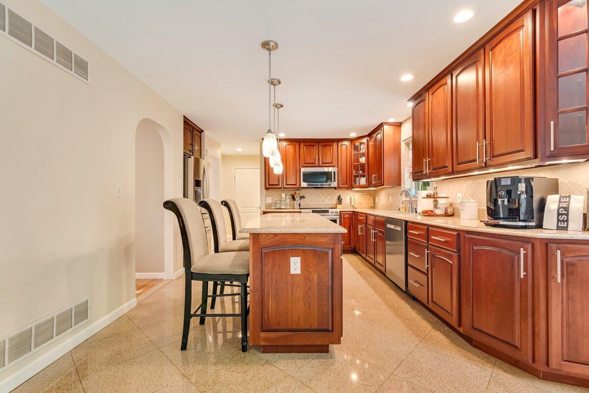 1376 Buck Ridge Drive Stroudsburg, PA 18360 - Photo 15 of 56 a kitchen with stainless steel appliances granite countertop a stove a sink dishwasher a dining table and chairs with wooden floor