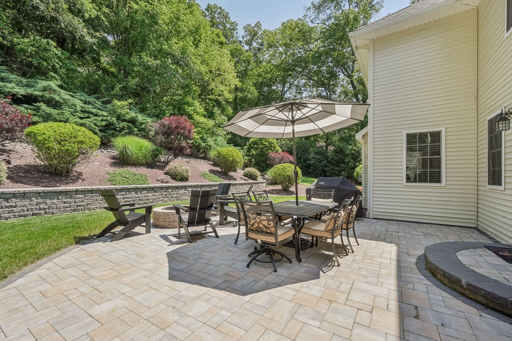 1376 Buck Ridge Drive Stroudsburg, PA 18360 - Photo 40 of 56 a view of a patio with table and chairs under an umbrella