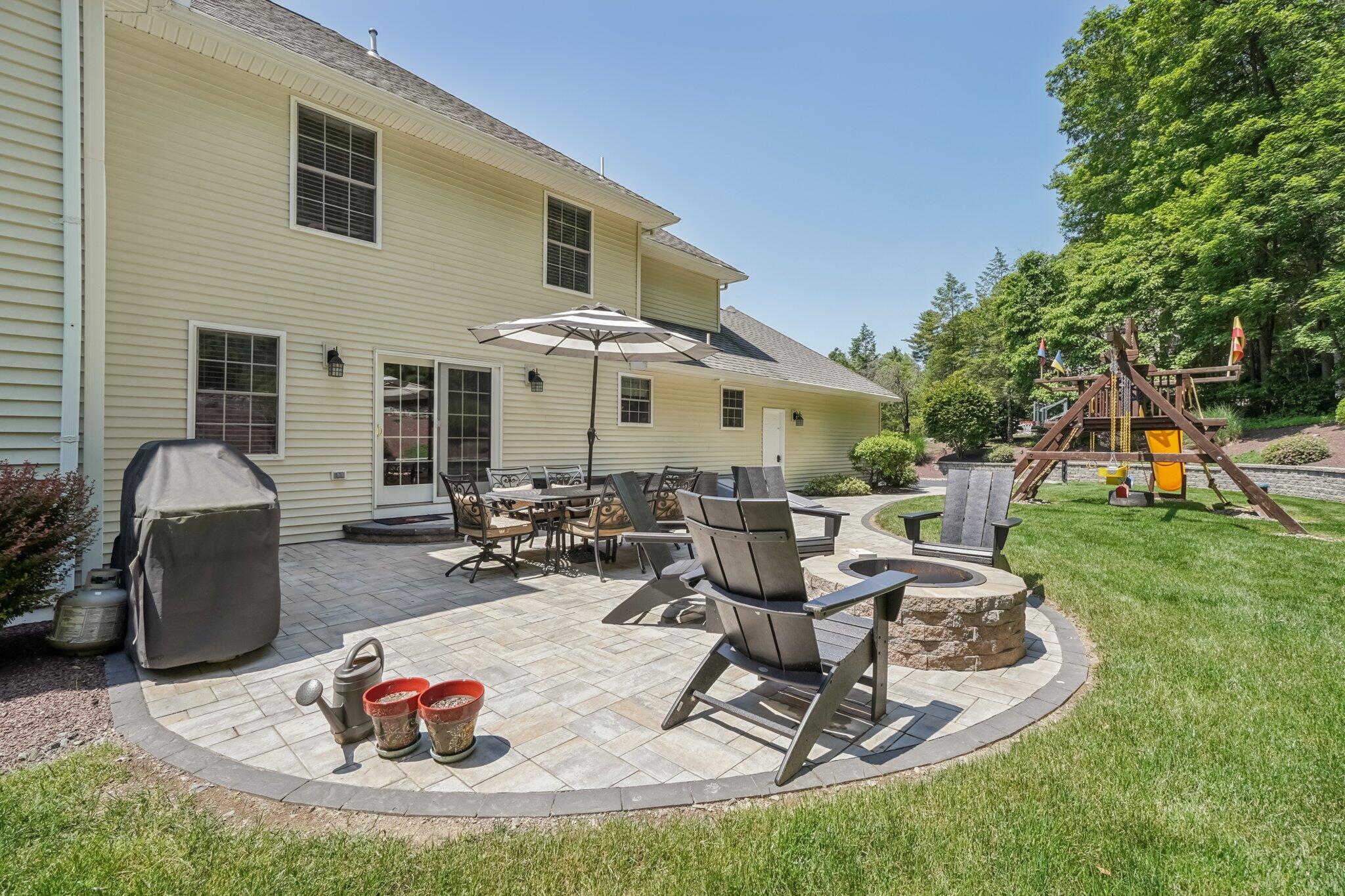 1376 Buck Ridge Drive Stroudsburg, PA 18360 - Photo 41 of 56 a view of a backyard with table and chairs potted plants and a fire pit