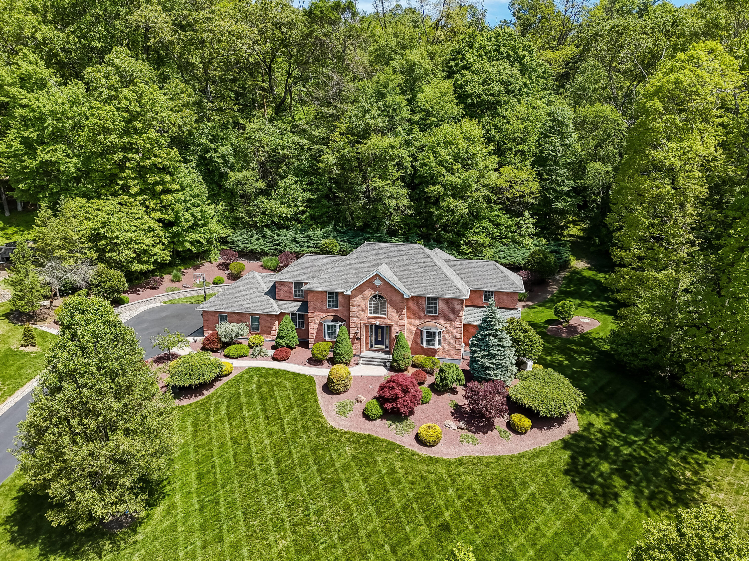 1376 Buck Ridge Drive Stroudsburg, PA 18360 - Photo 44 of 56 a front view of a house with a garden and trees