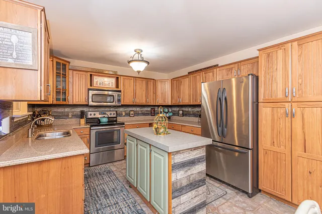 a kitchen with stainless steel appliances granite countertop a refrigerator stove and sink