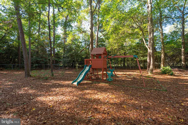 a backyard of a house with childrens swings and slides