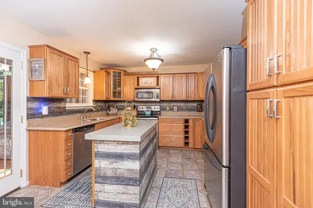 a large kitchen with kitchen island granite countertop a large window and a sink