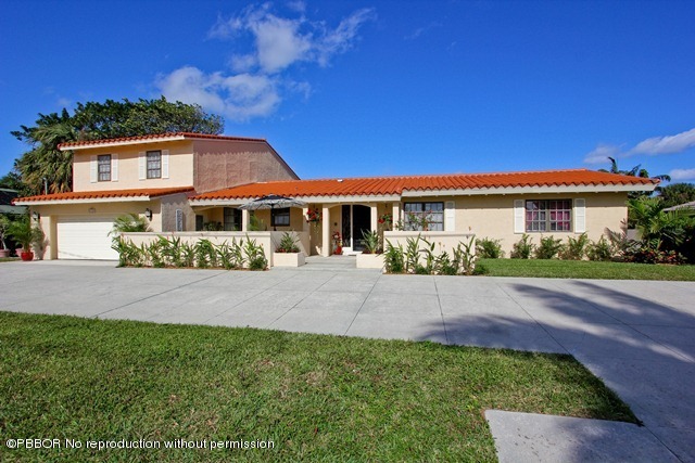 1180 Singer Drive Riviera Beach, FL 33404 - Photo 2 of 16 a front view of a house with a yard and garage