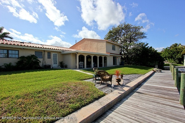 1180 Singer Drive Riviera Beach, FL 33404 - Photo 16 of 16 a view of a house with backyard and a tree