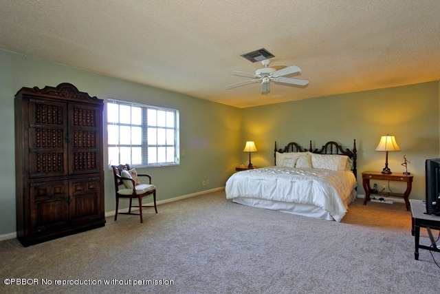 1180 Singer Drive Riviera Beach, FL 33404 - Photo 8 of 16 a spacious bedroom with a bed and a chandelier