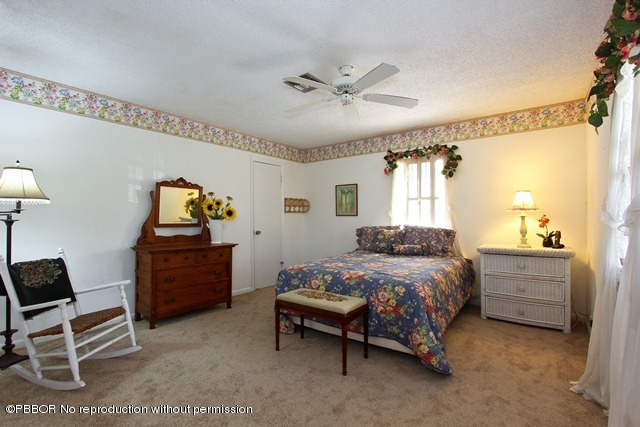 1180 Singer Drive Riviera Beach, FL 33404 - Photo 10 of 16 a bedroom with a bed and a chandelier