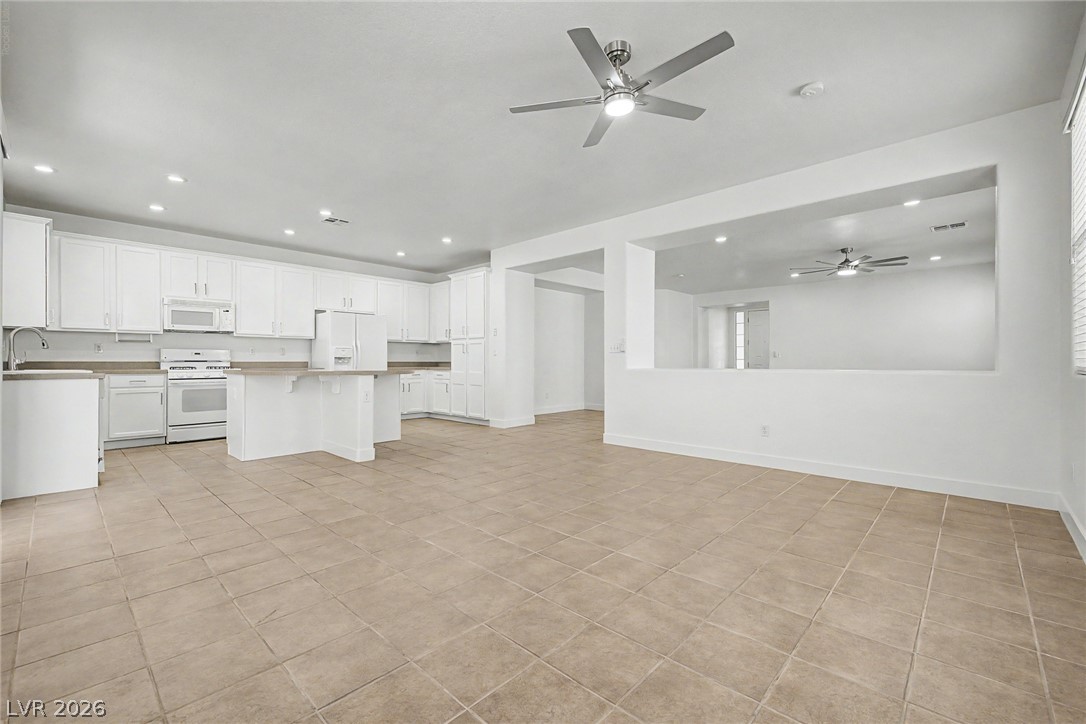 835 Entrada Ridge Avenue Henderson, NV 89012 - Photo 8 of 34 An open concept design seamlessly connects the well-appointed kitchen to the adjacent living areas, all set atop durable tile flooring.