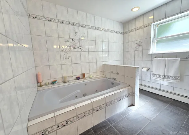 a bathroom with a tub sink and cabinets