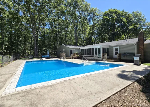 a view of a house with swimming pool and sitting area