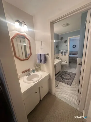 a bathroom with a sink mirror vanity and toilet