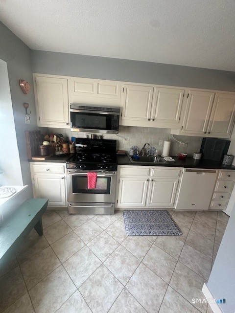 25 Farmington Chase Crescent, Unit 25 Farmington, CT 06032 - Photo 5 of 18 a kitchen with stainless steel appliances kitchen island granite countertop a stove a sink and a microwave