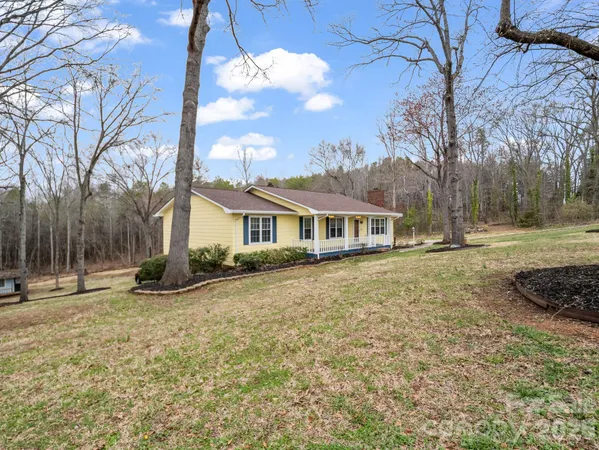 a front view of a house with a yard and trees