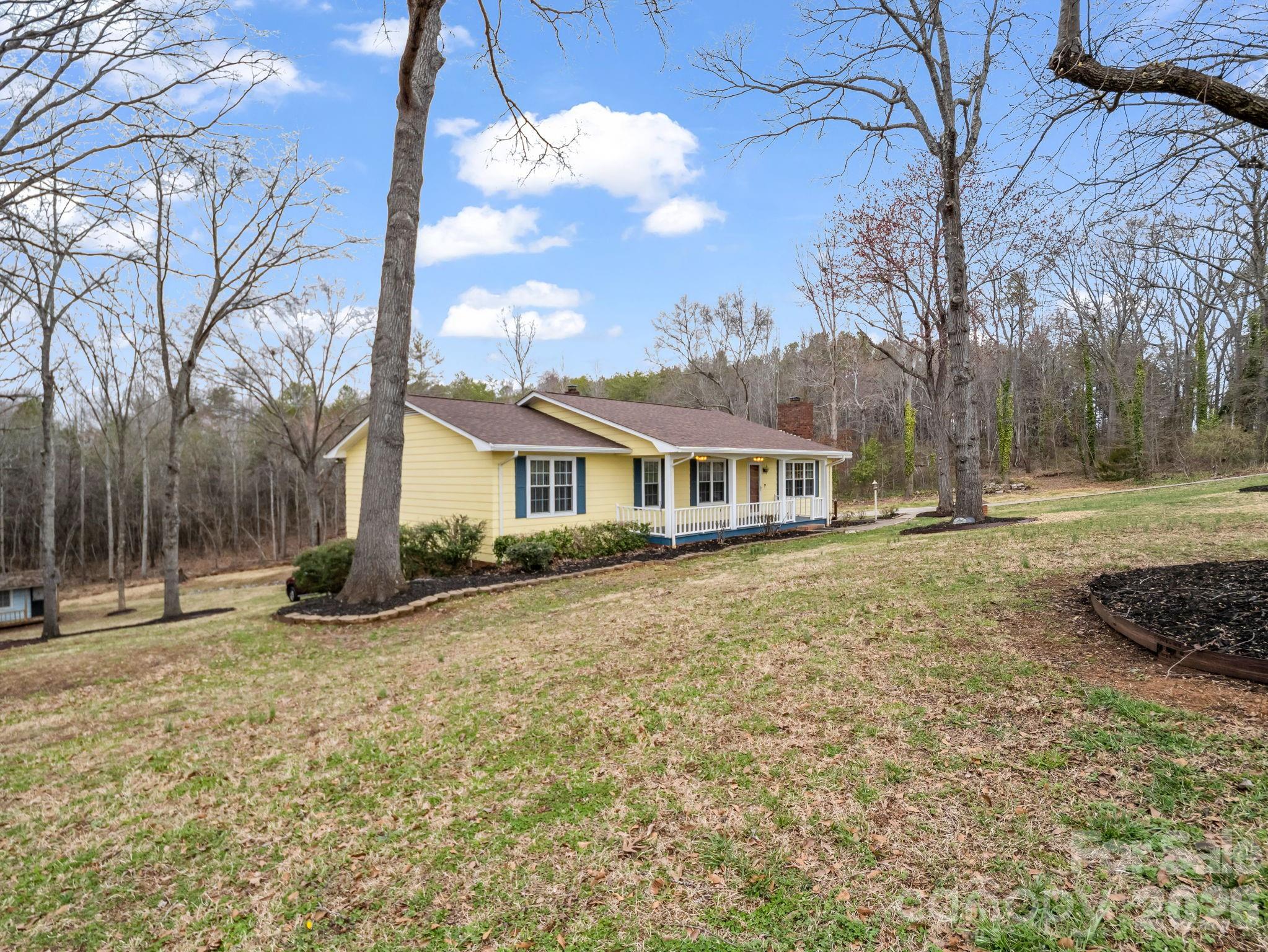 a front view of a house with a yard and trees