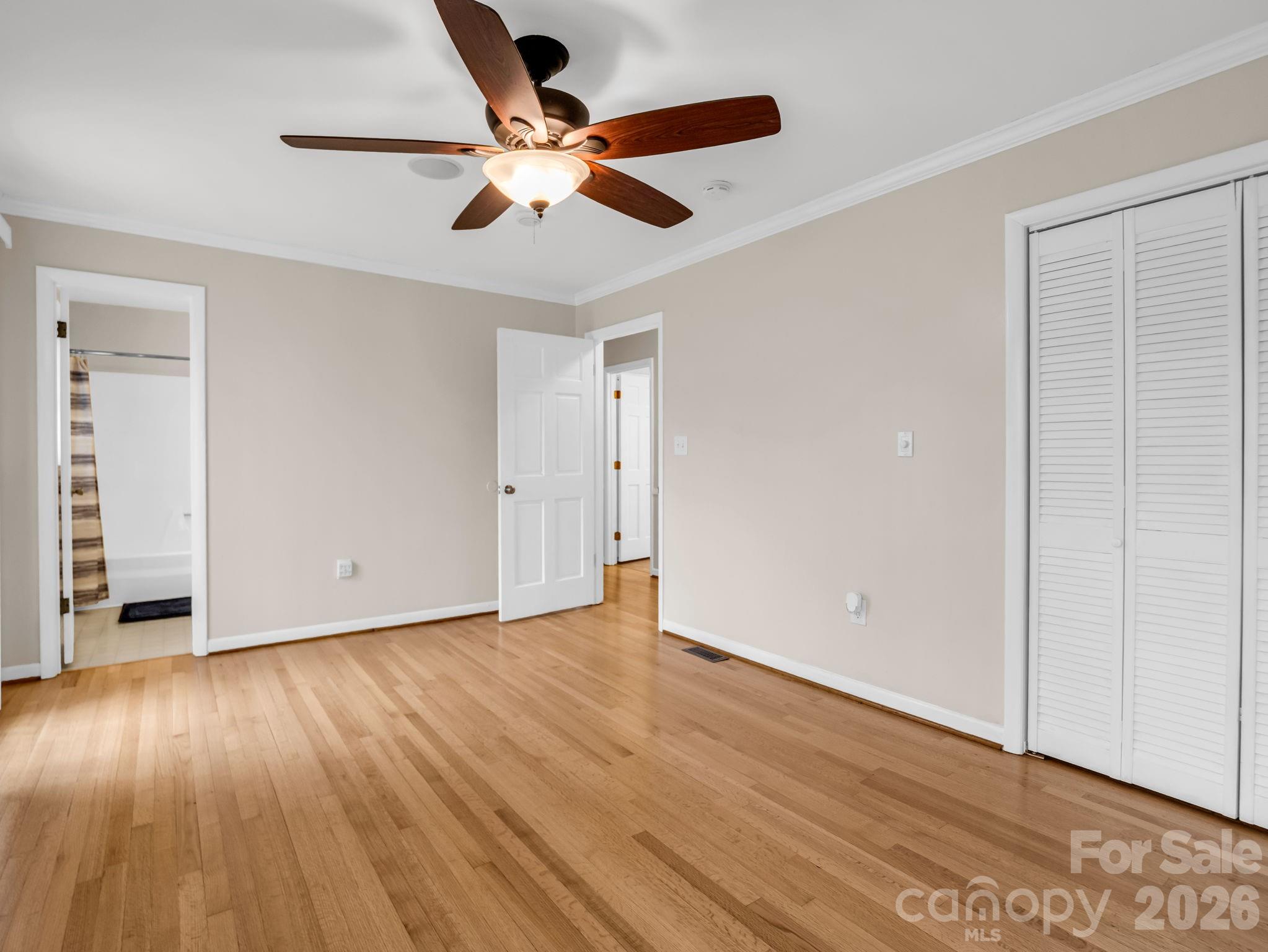 315 Walker Store Road Ellenboro, NC 28040 - Photo 20 of 39 an empty room with wooden floor chandelier fan and windows