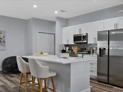 a kitchen with stainless steel appliances a microwave sink refrigerator and cabinets