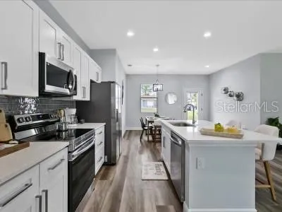 a kitchen with stainless steel appliances a stove sink microwave and cabinets