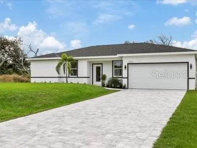 a view of a house with a yard and a large tree