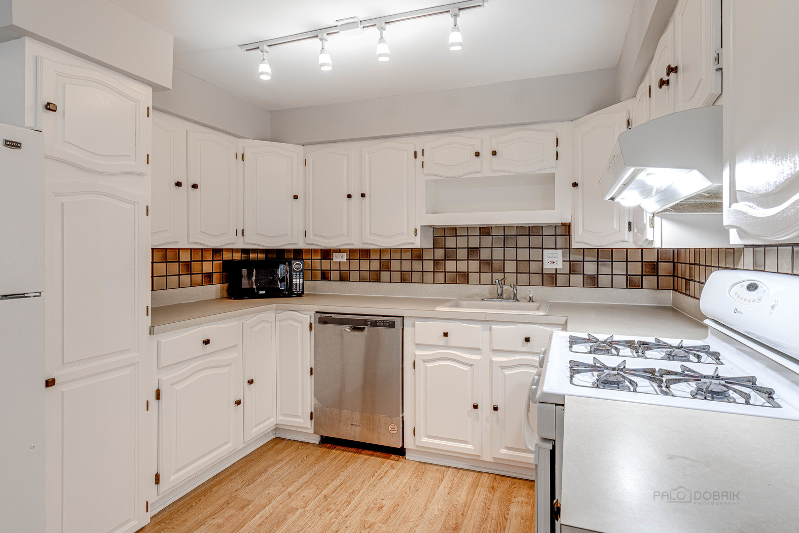 1100 Stoughton Court, Unit 1711 Schaumburg, IL 60193 - Photo 15 of 25 a kitchen with stainless steel appliances white cabinets a sink a stove a refrigerator and white cabinets