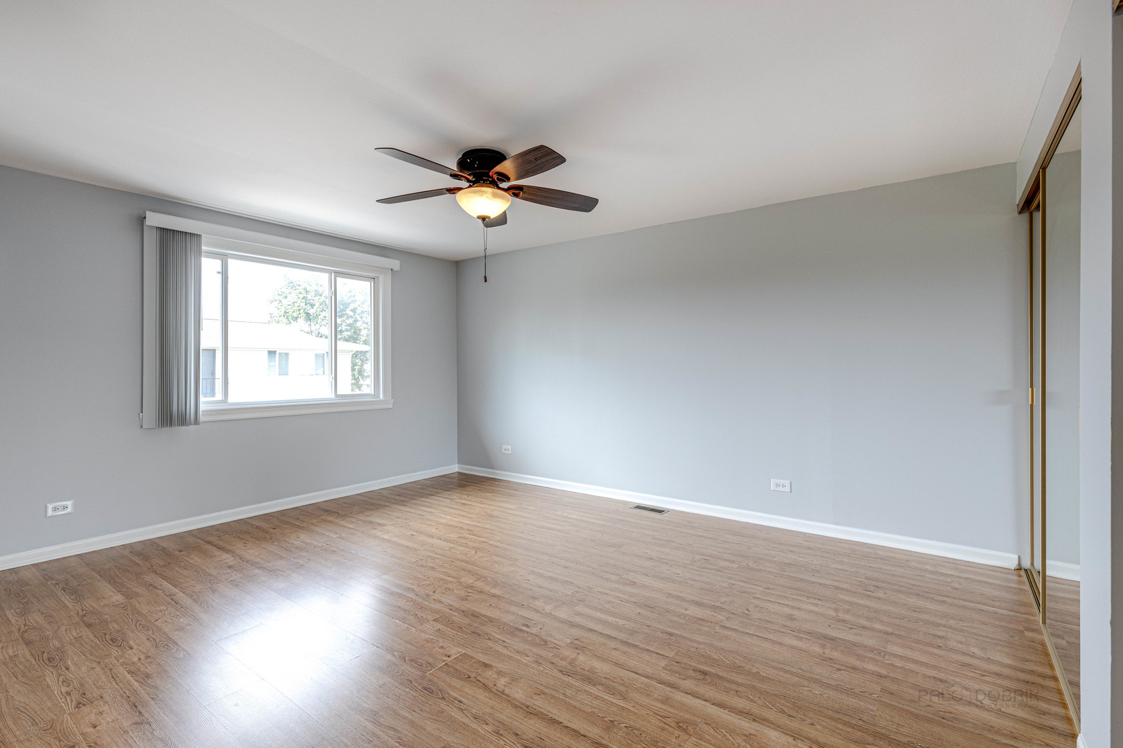 1100 Stoughton Court, Unit 1711 Schaumburg, IL 60193 - Photo 17 of 25 a view of an empty room with a window and wooden floor