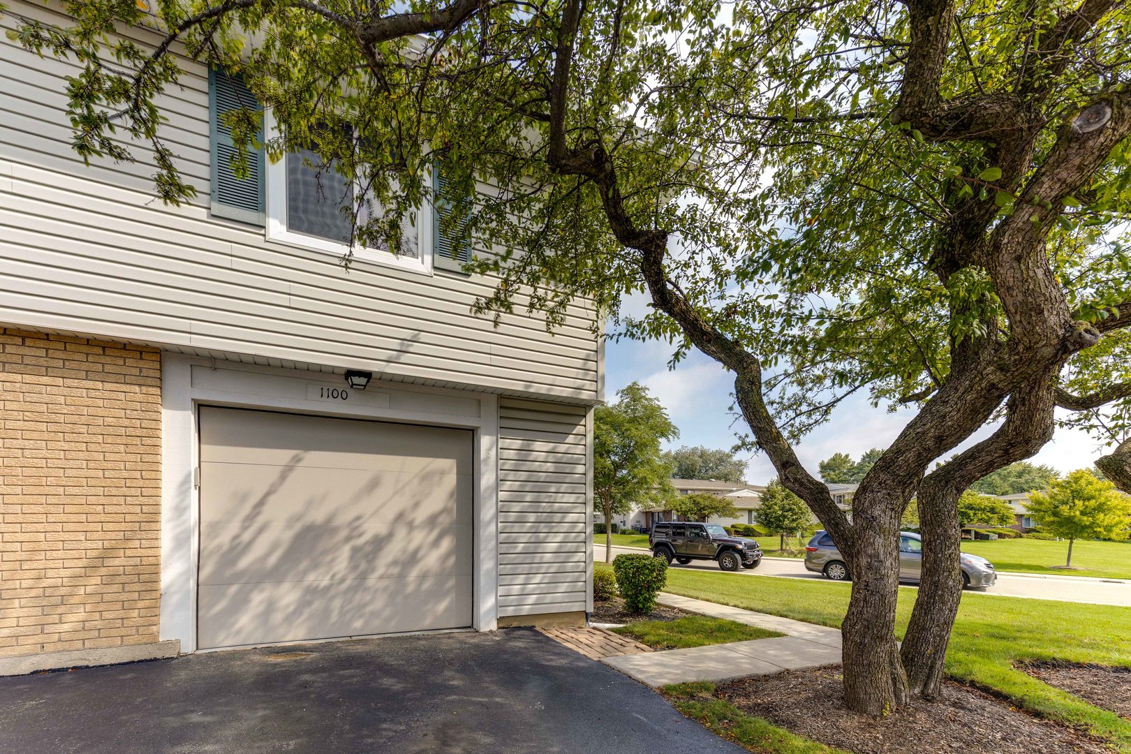 1100 Stoughton Court, Unit 1711 Schaumburg, IL 60193 - Photo 22 of 25 a view of a house with a tree and wooden fence